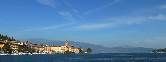 Adults-only beliebte Urlaubsziele am Gardasee -  Mit einer Fläche von 370 km² ist der Gardasee der größte See Italiens. Es liegt am Fuße der Alpen und erstreckt sich über drei Staaten: Lombardei, Venetien und Trentino. Die maximale Tiefe des Sees beträgt 346 m, er hat eine längliche Form und sein nördliches Ende ist sehr schmal. Dort ist der See von den Bergen der Gruppo di Baldo umgeben. Du trittst aus deinem gemütlichen Hotelzimmer und es begrüßt dich die warme italienische Sonne. Du blickst auf den atemberaubenden Gardasee, der in zahlreichen Blautönen schimmert - von tiefem Dunkelblau bis zu funkelndem Türkis. Majestätische Berge umgeben dich, während die Brise sanft deine Haut streichelt und der Duft von blühenden Zitronenbäumen deine Nase kitzelt. Du schlenderst die malerischen, engen Gassen entlang, vorbei an farbenfrohen, blumengeschmückten Häusern. Vereinzelt unterbricht das fröhliche Lachen der Einheimischen die friedvolle Stille. Du fühlst dich wie in einem Traum, der nicht enden will. Jeder Schritt führt dich zu neuen Entdeckungen und Abenteuern. Du probierst die köstliche italienische Küche mit ihren frischen Zutaten und verführerischen Aromen. Die Sonne geht langsam unter und taucht den Himmel in ein leuchtendes Orange-rot - ein spektakulärer Anblick.